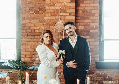 bride and groom standing behind wedding set up