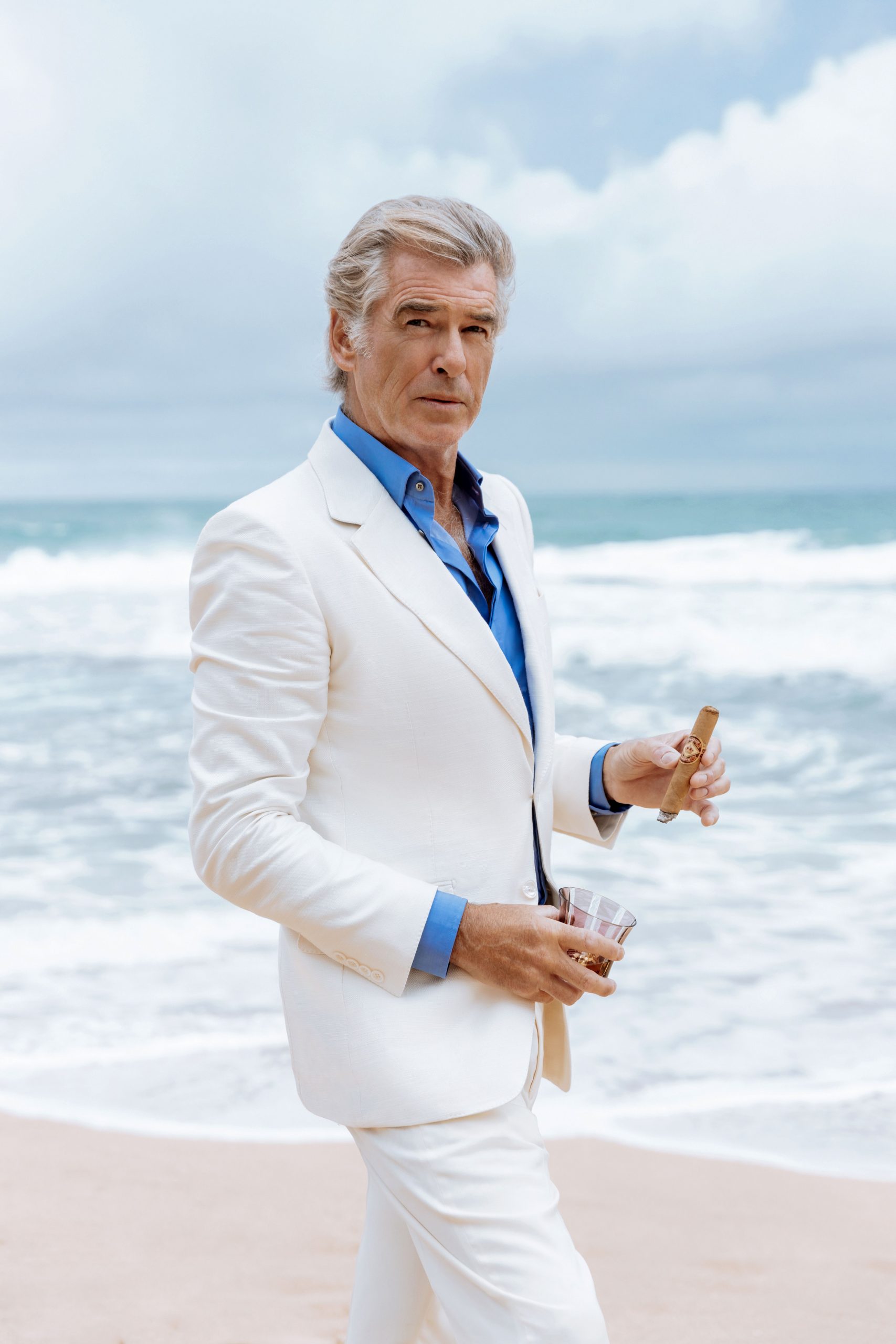 pierce brosnan smoking diamond crown cigar on the beach