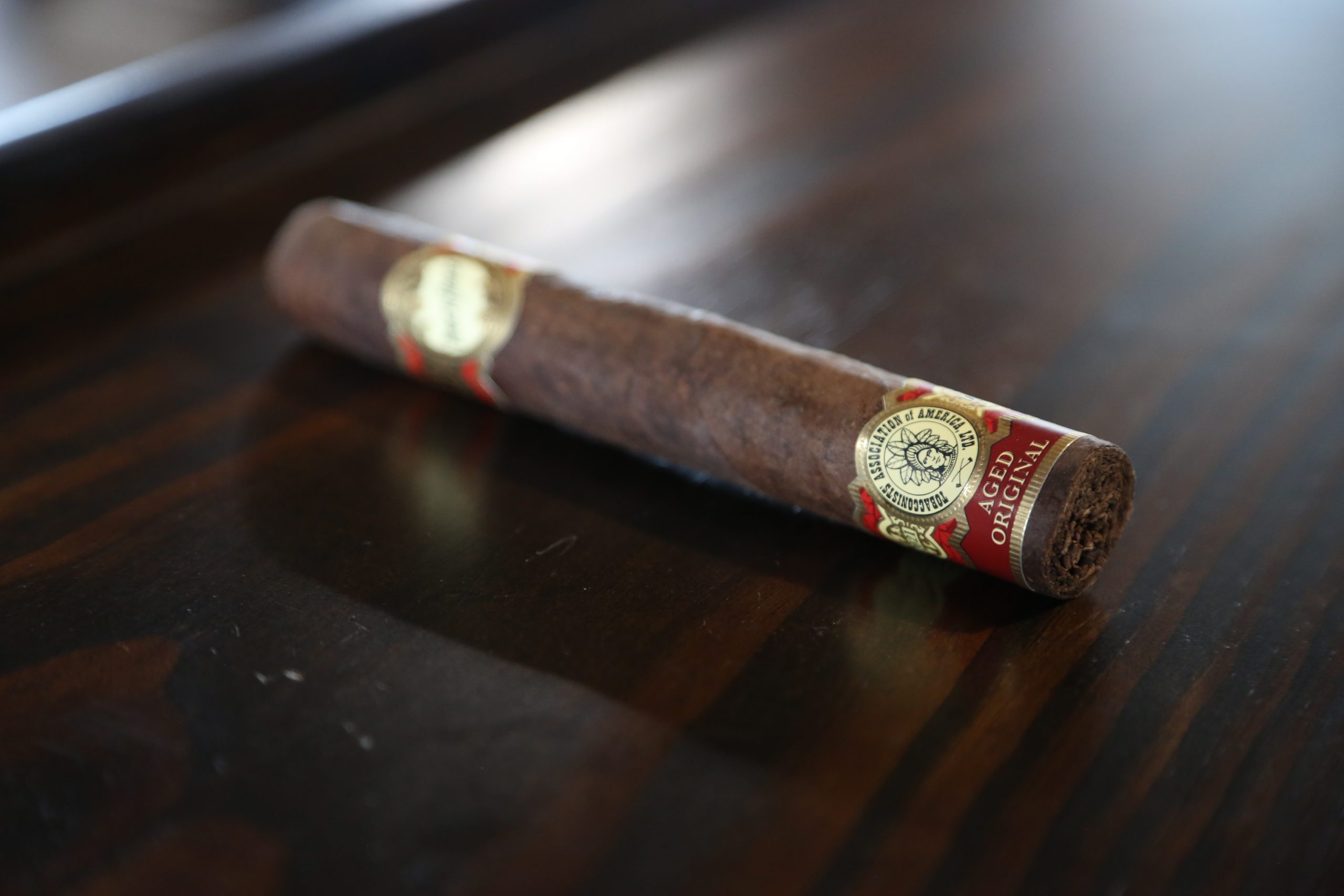 bhb1 brick house cigar on cigar rolling table with tobacconist association of america red cigar footband