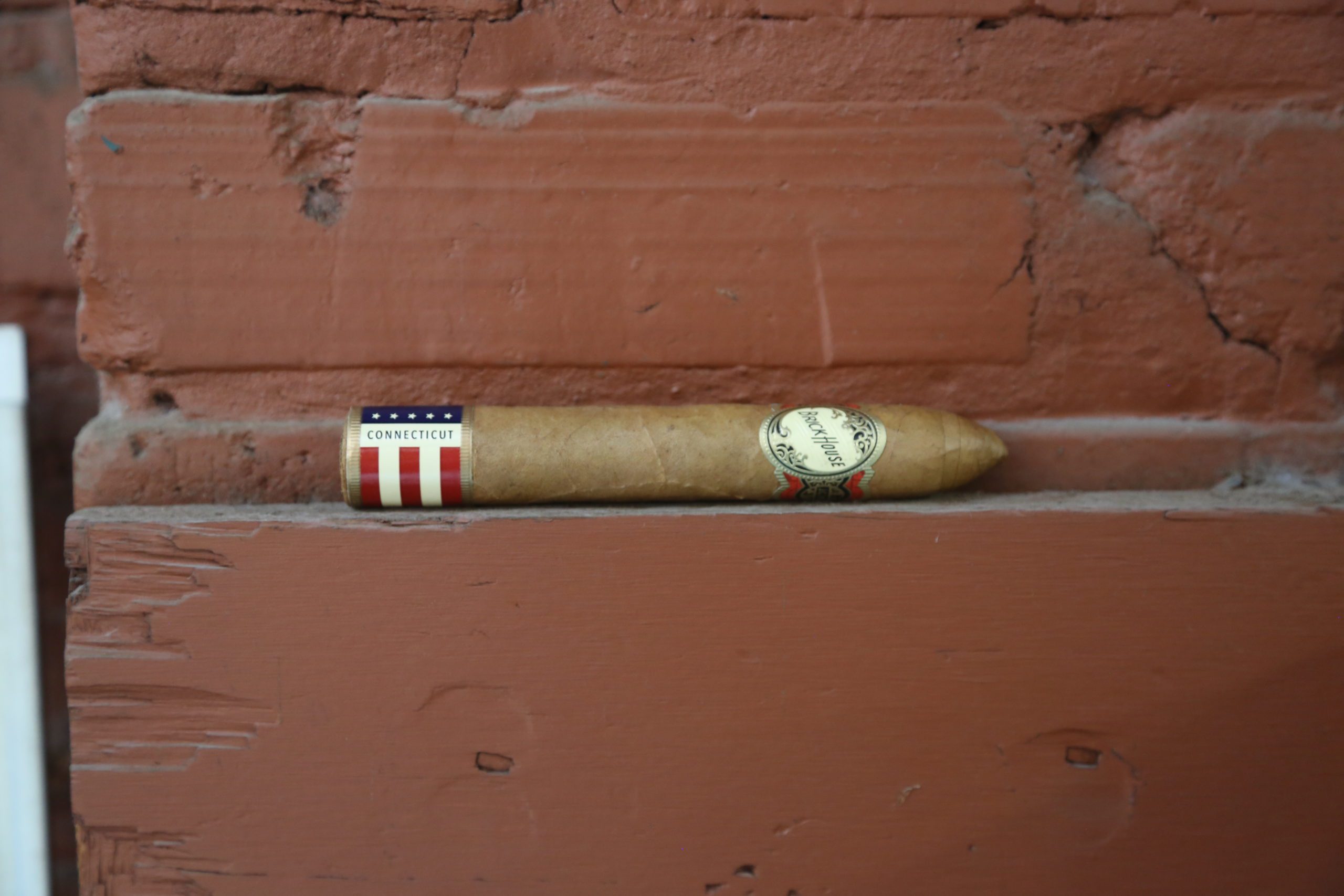 brick house double connecticut short torpedo cigar on a brick ledge