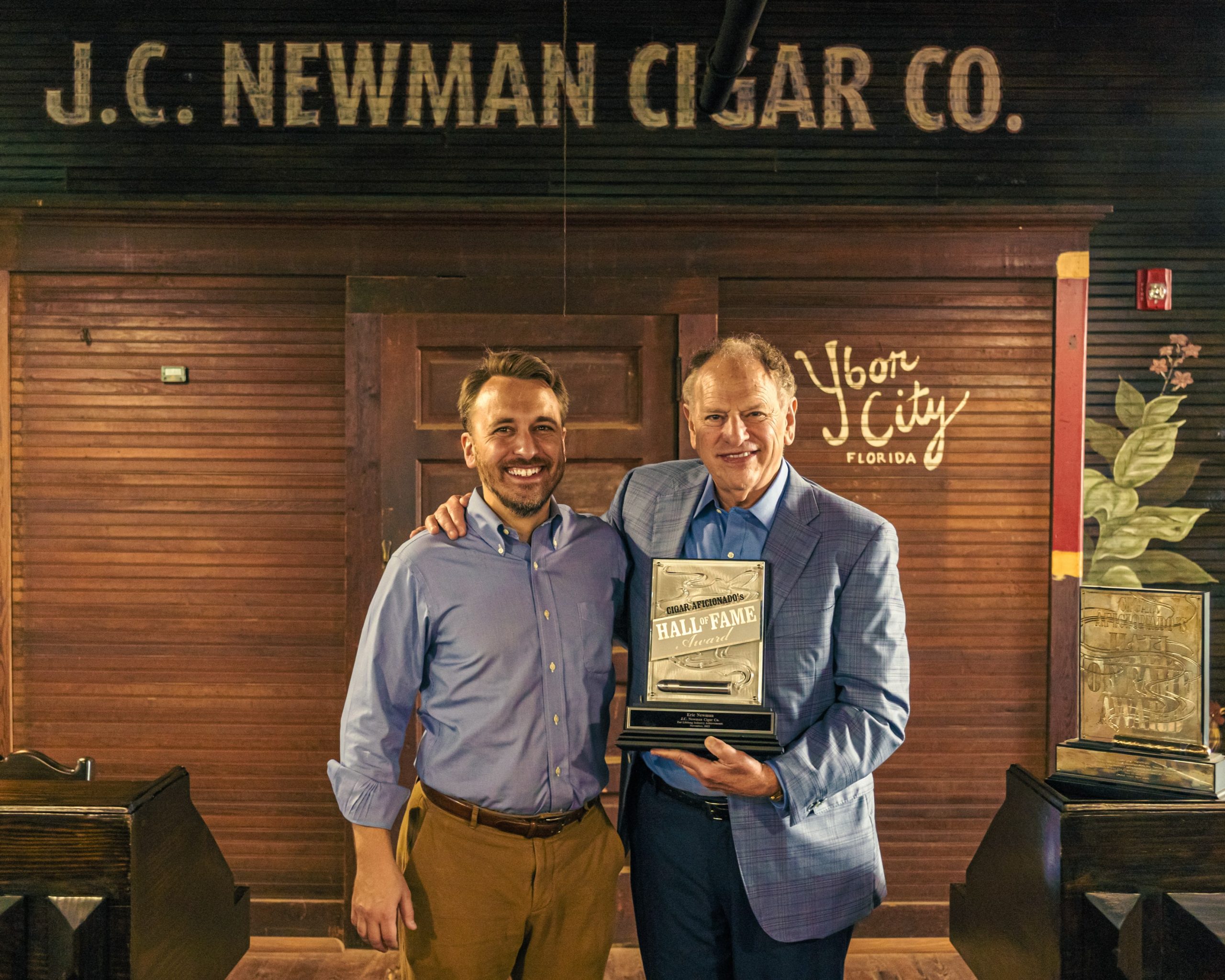 eric newman with his son drew newman posing with award
